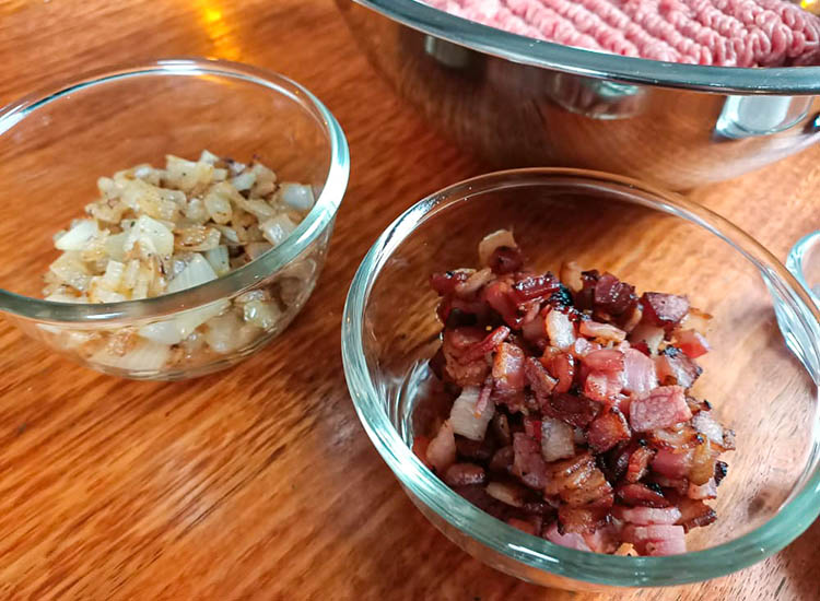 fried bacon and onions in glass bowls on a wooden table