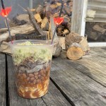 clear quart cup layered with mac, beans, pork, slaw with 2 lit sparklers