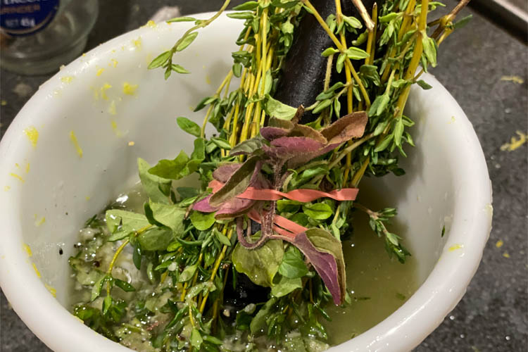 white bowl with oil and herbs and a mop brush