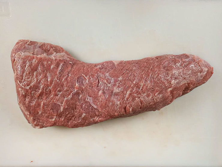 raw tri tip on a plastic board