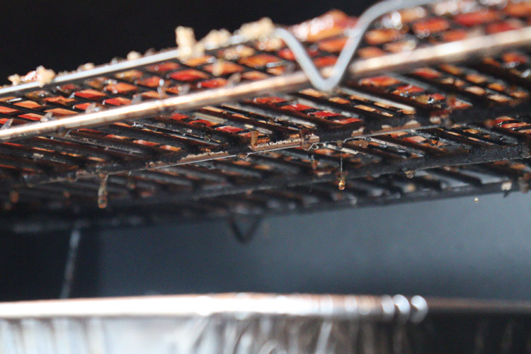 bacon on a rack with fat drips into a foil tray