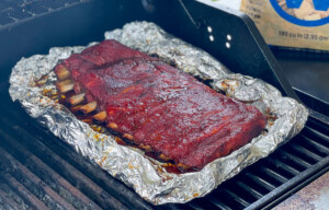 rack of ribs smoking on a gas grill
