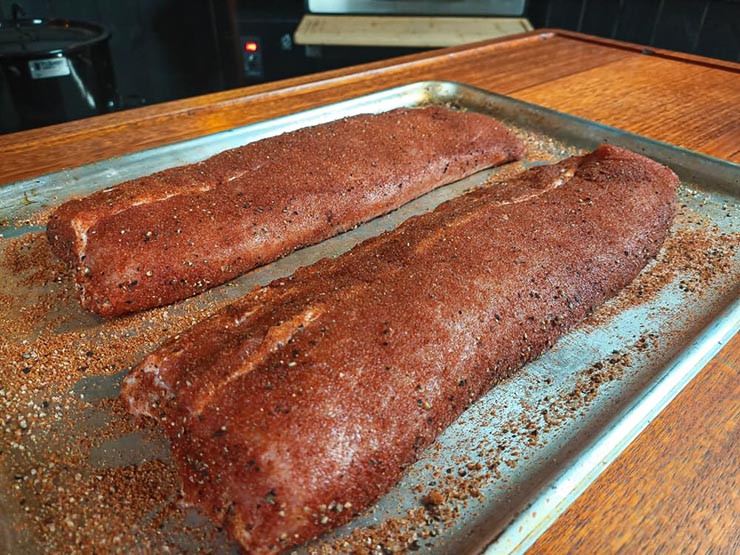 seasoned pork baby back ribs on a metal baking tray