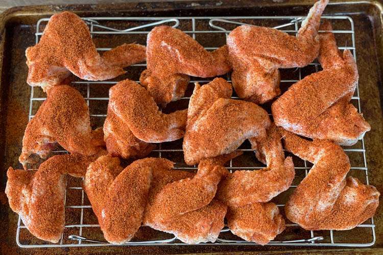 raw seasoned wings on a wire rack