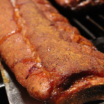a slab of baby back ribs smoking on a pellet grill