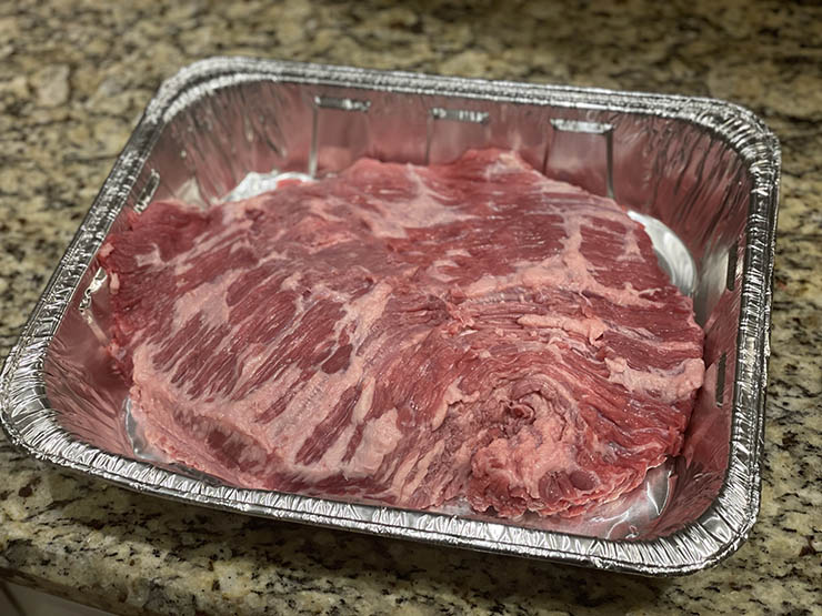 uncooked brisket point in a baking tray
