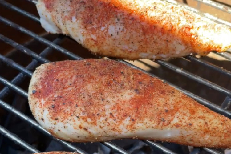 seasoned chicken cooking on grill