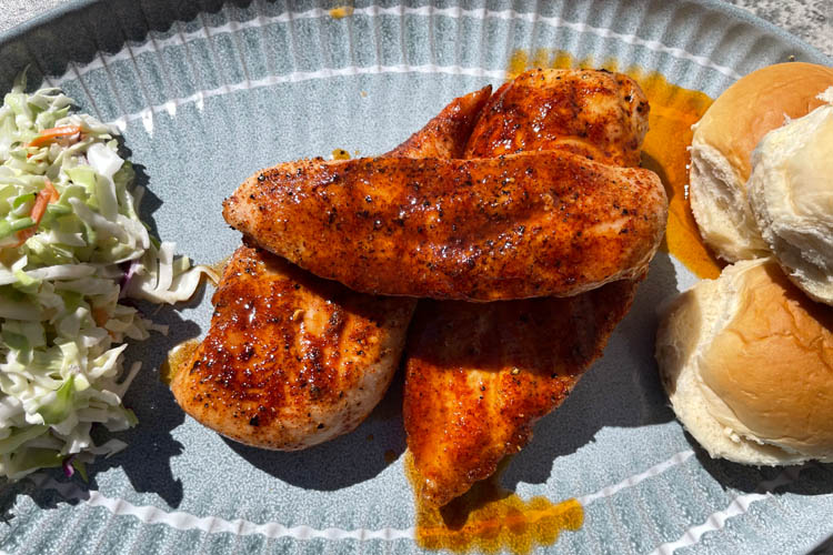 a plate with nashville chicken, coleslaw and buns