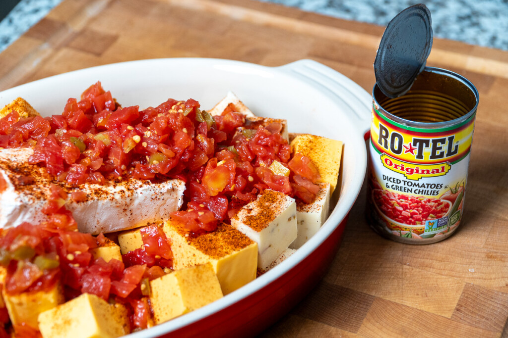 queso cheese ingredients in a red bowl with Rotel tomatoes poured over 