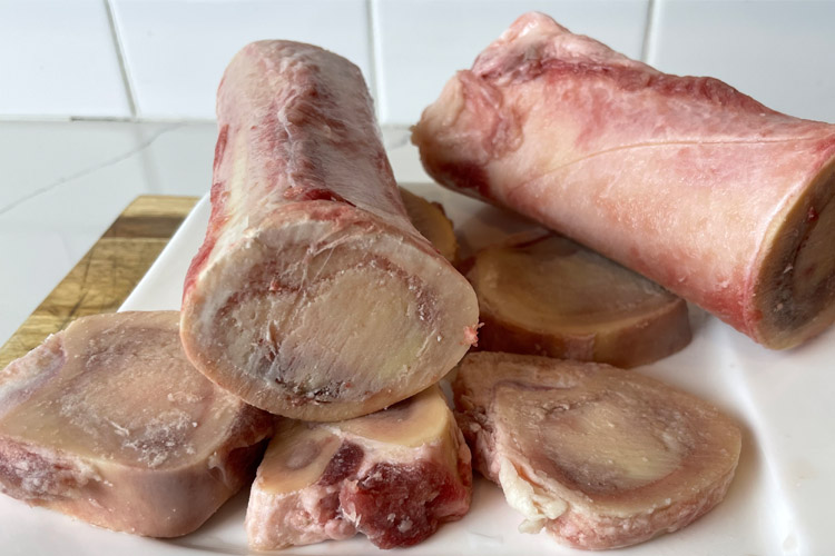 raw bone marrow on a white chopping board