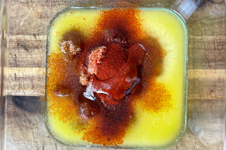 all sauce ingredients in a glass bowl on wooden chopping  board