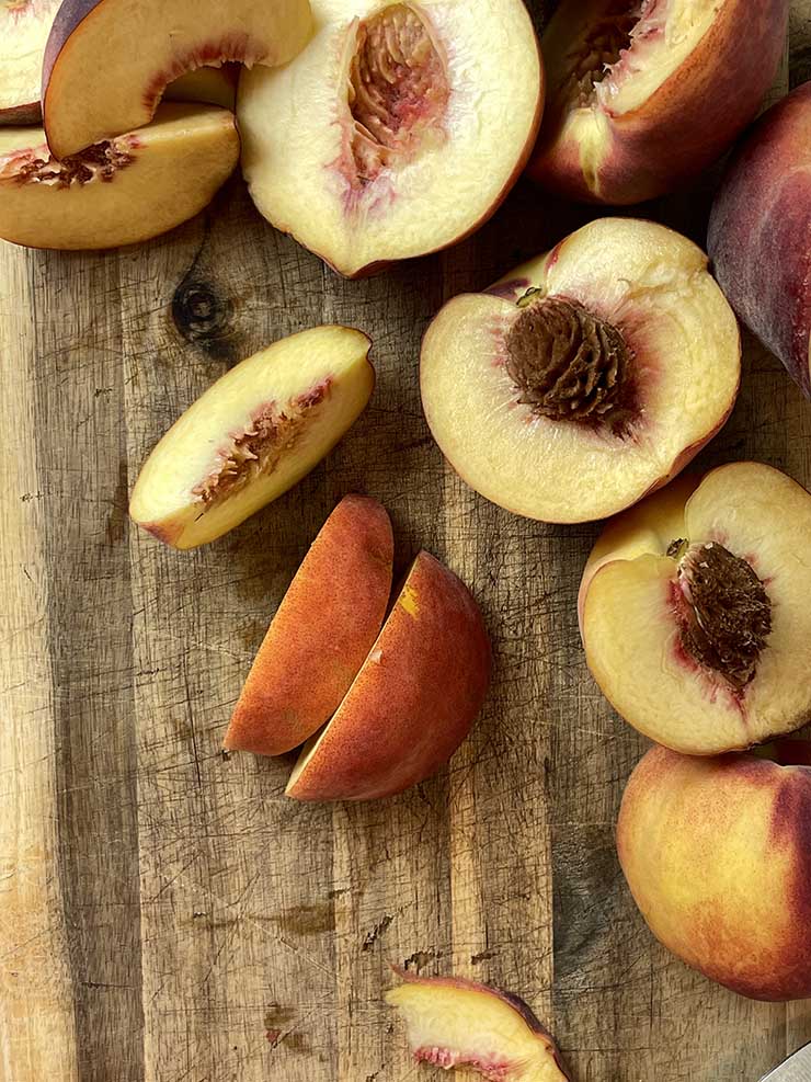 sliced peaches on a wooden board
