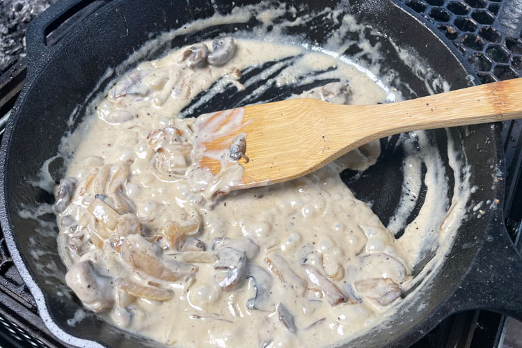 mushroom sauce in a cast iron skillet on the grill
