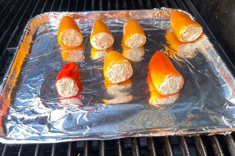 stuffed peppers on aluminum cover tray on the grill