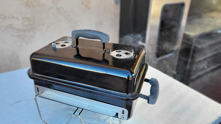 smoke coming from the top vent of the weber go-anywhere grill