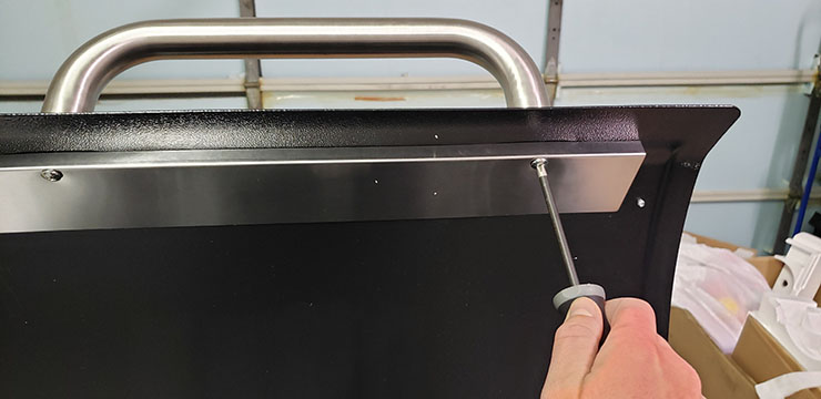 a man assembling Camp Chef DLX 24 with a screwdriver