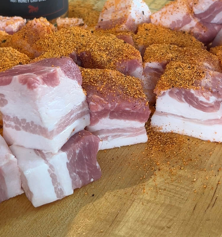 cubes of pork belly with seasoning sprinkled on top
