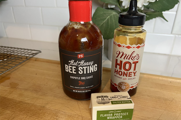a bottle of bbq sauce, hot honey and block of butter