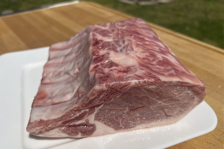 raw rack of pork on a white board