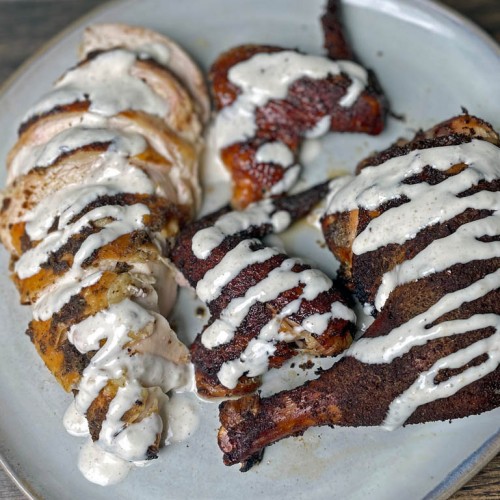 smoked chicken with alabama white sauce on on a plate