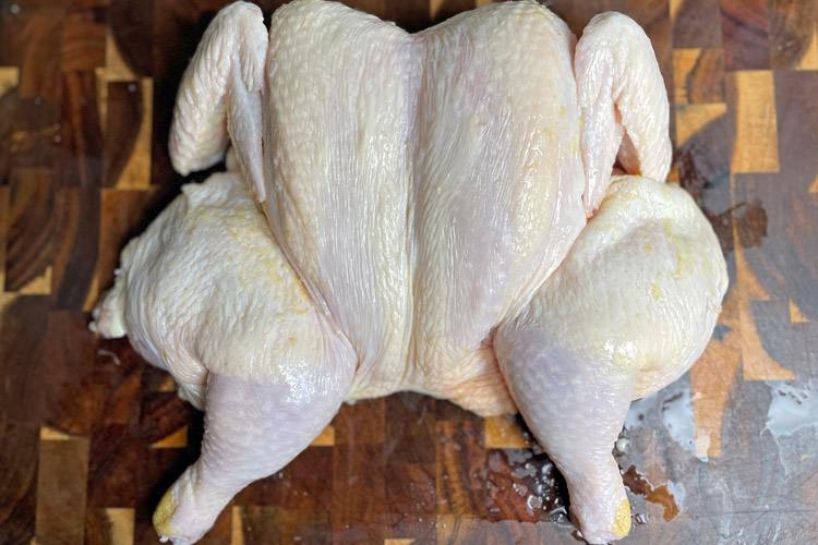 spatchcocked chicken on a wooden board