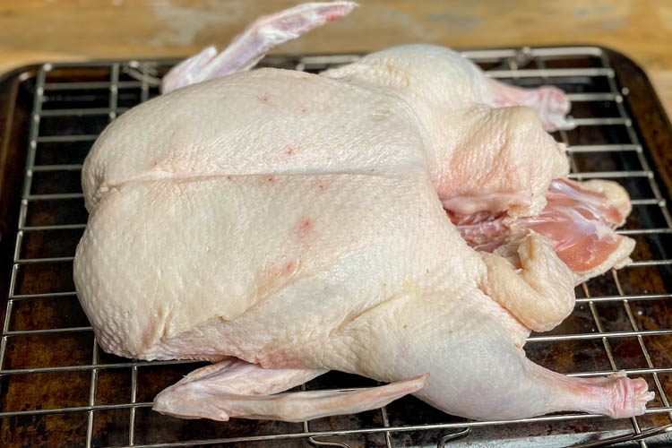 raw duck with piercing on wire rack
