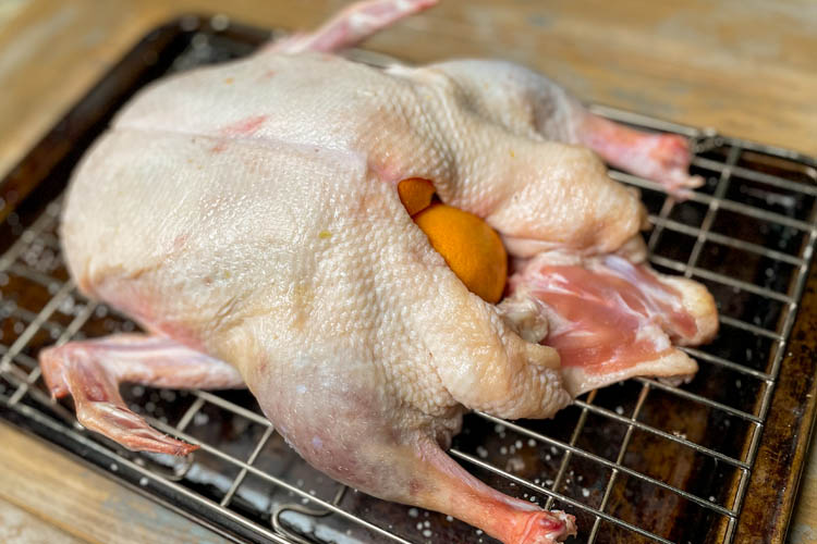 raw duck stuff with orange on a wire rack