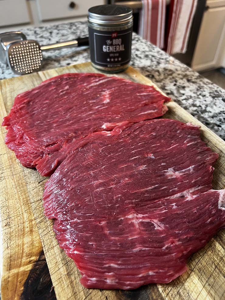 Butterflied flank steak on a wooden board