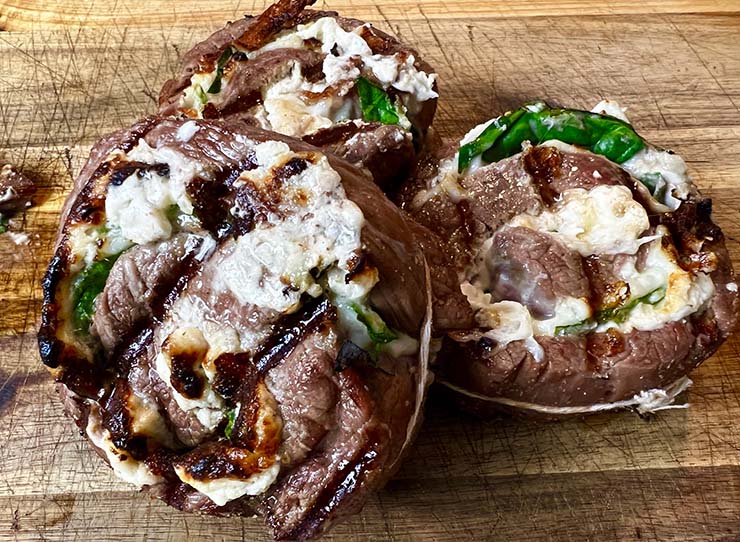 grilled steak pinwheels on a wooden board