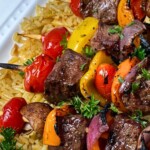 grilled steak kabobs over a bed of rice
