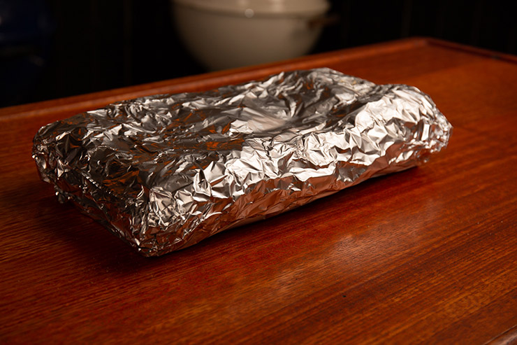 pork spare ribs wrapped in foil on a wooden table
