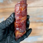 gloved hand holding smoked shotgun shell