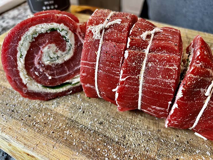 uncooked steak pinwheels on a wooden board