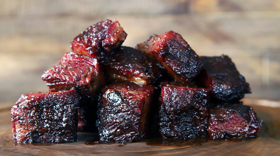 brisket burnt ends served on wood cutting board