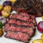 sliced coffee crusted ribeye steak with grill vegetable on the side