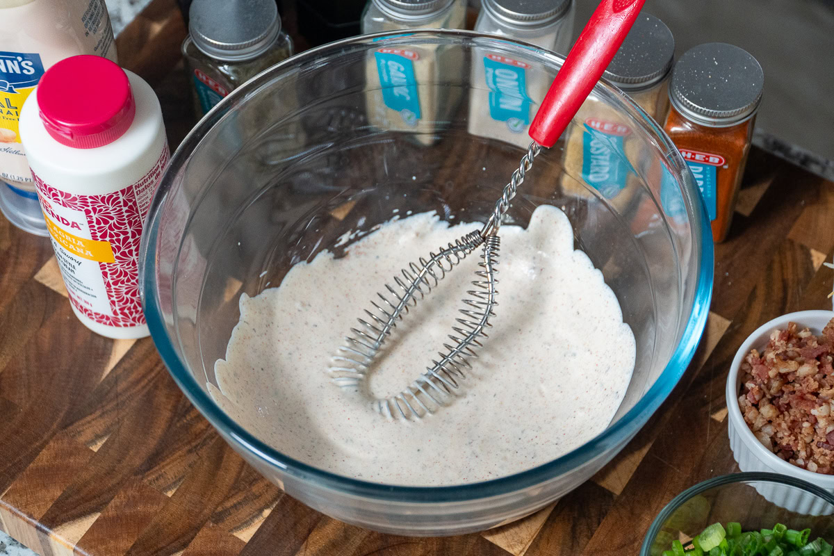 a bowl with the dressing mixture in it and a whisk 
