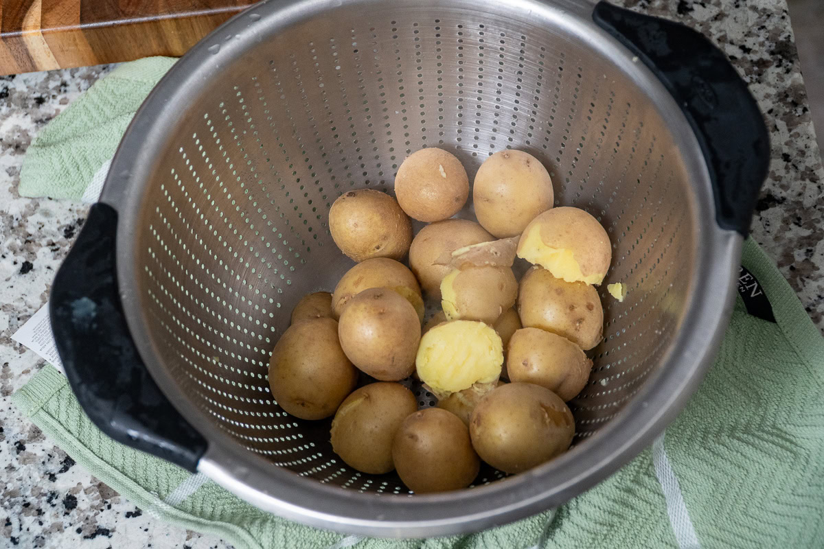 cooked whole potatoes in a colander