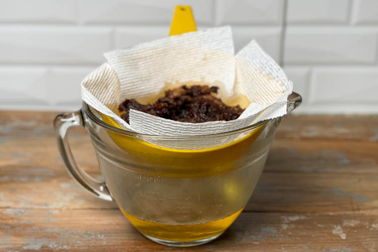 jug with paper towel sieve with sediment in it