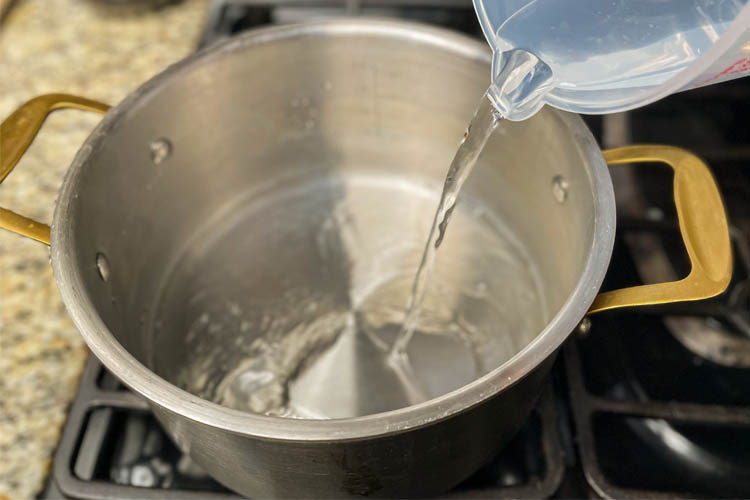 water being poured into a stock pot