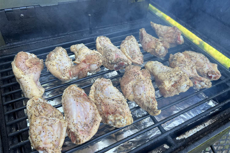 raw seasoned wings on the grill