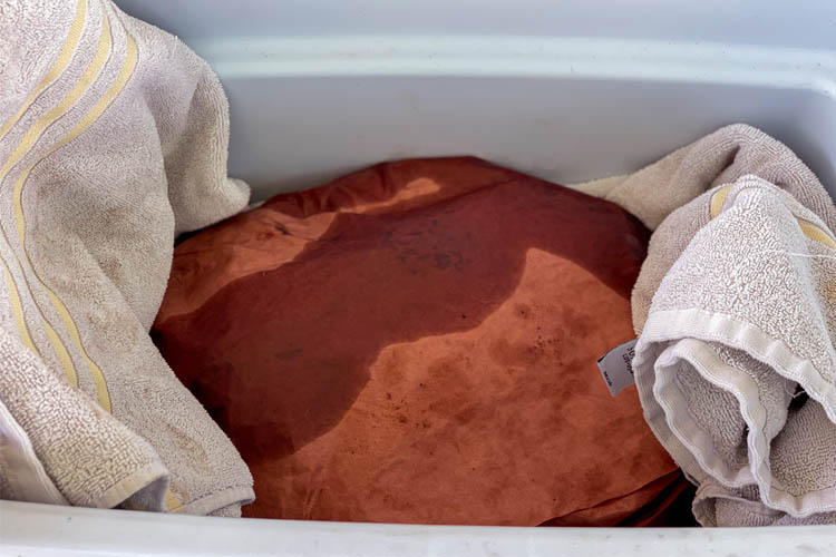 brisket wraped in butcher paper in towel in cooler