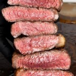 gloved hands holding sliced grilled rump cap steaks