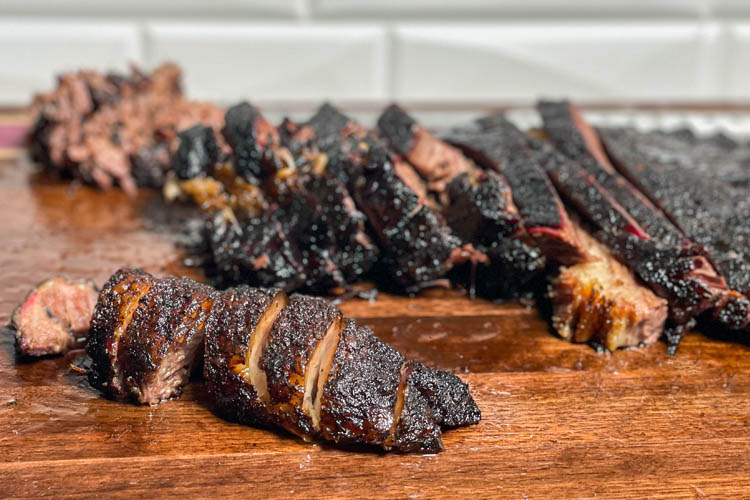 sliced brisket on a wooden chopping board