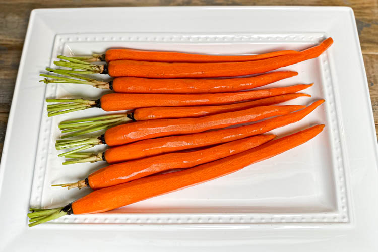 raw peeled carrots on white plate