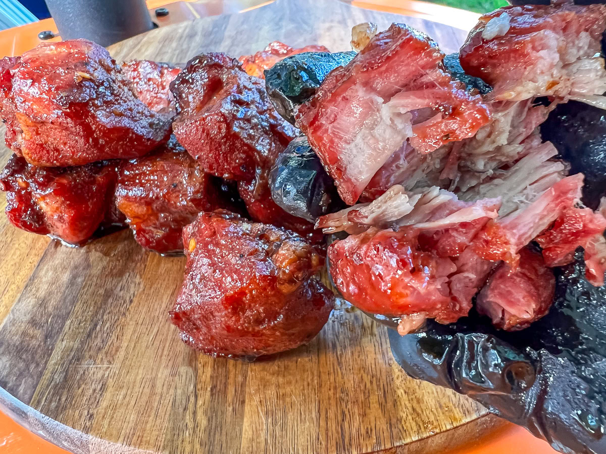 Sticky, glistening pork burnt ends served on wood board