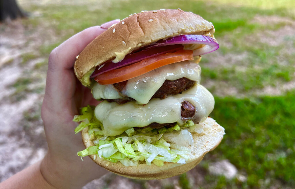 holding grilled bison burger