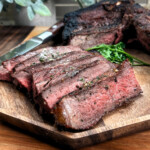 slices of grilled New York Strip steak on a wooden plate
