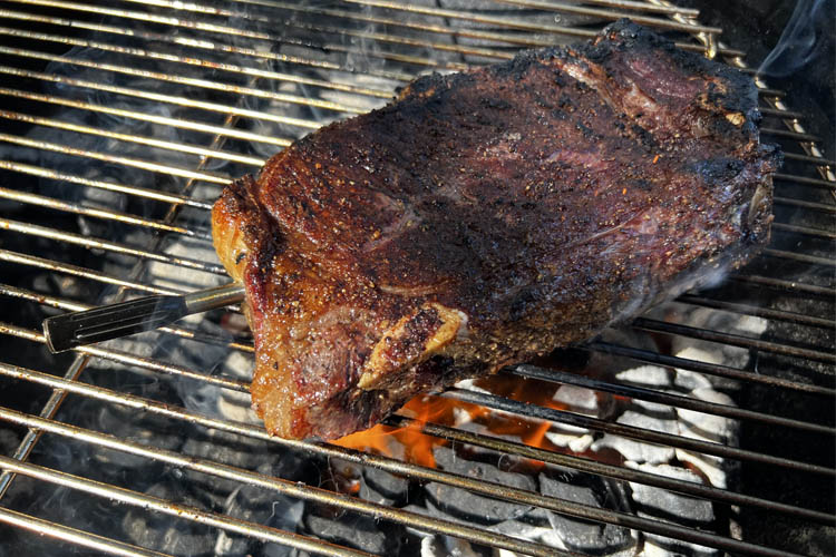 cooked new york strip steak on a charcoal grill