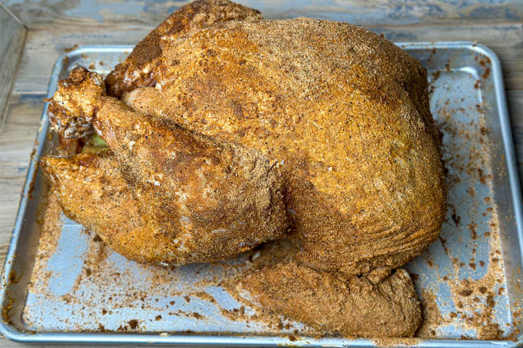 raw seasoned turkey on a silver tray