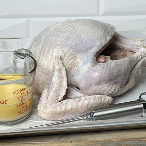 turkey injection liquid next to raw turkey and injector